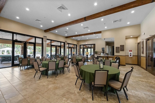 dining room featuring a wealth of natural light, french doors, beamed ceiling, and a high ceiling