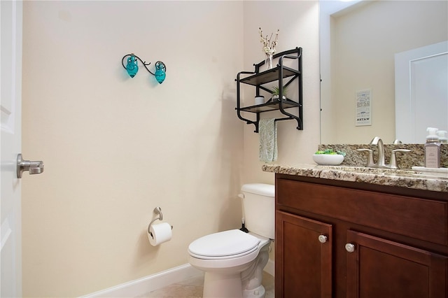 bathroom featuring vanity, tile patterned floors, and toilet