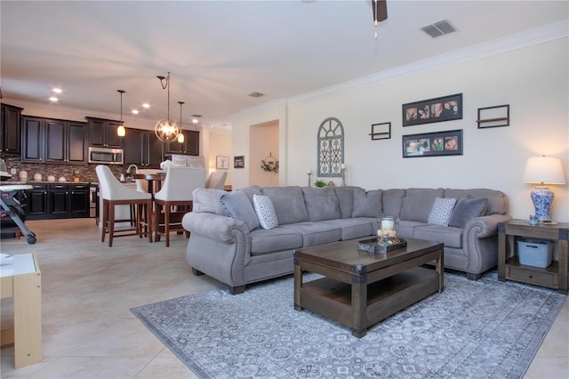 tiled living room with crown molding and ceiling fan