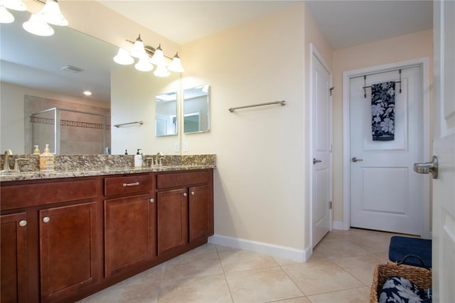 bathroom with walk in shower, vanity, and tile patterned flooring