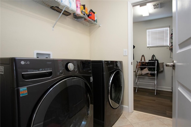 laundry area featuring light tile patterned floors and washing machine and clothes dryer