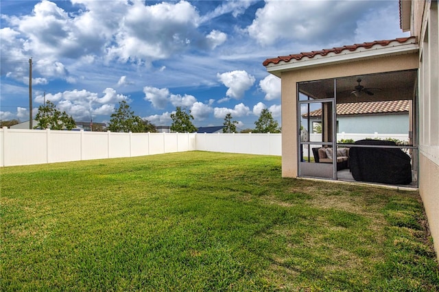 view of yard with a sunroom and ceiling fan