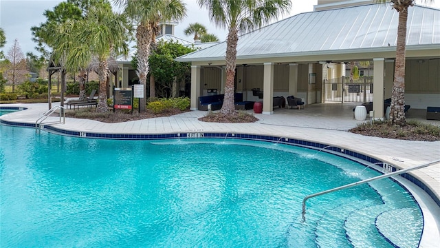 view of pool featuring pool water feature, ceiling fan, and a patio area