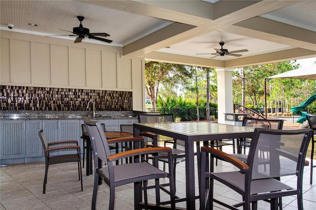 view of patio / terrace featuring ceiling fan, a playground, and an outdoor wet bar