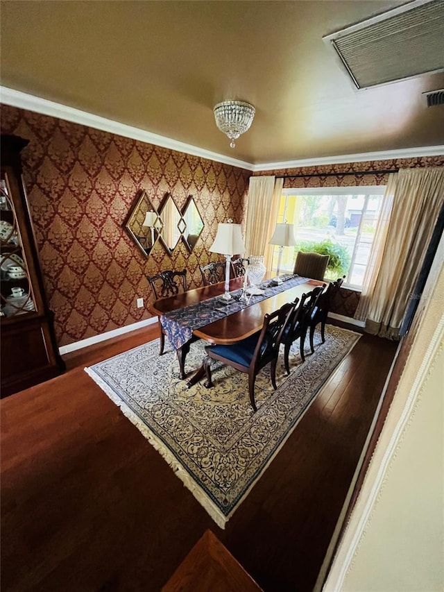 dining space with hardwood / wood-style flooring and ornamental molding