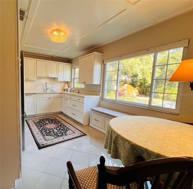 kitchen featuring light tile patterned flooring, plenty of natural light, sink, and white cabinets