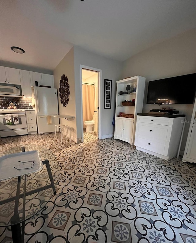 kitchen featuring backsplash, white appliances, and white cabinets