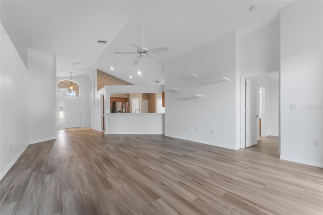 unfurnished living room featuring high vaulted ceiling, light hardwood / wood-style floors, and ceiling fan