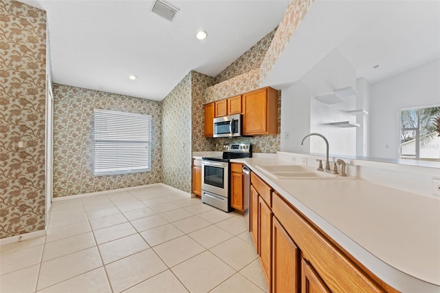 kitchen featuring appliances with stainless steel finishes, sink, and light tile patterned floors