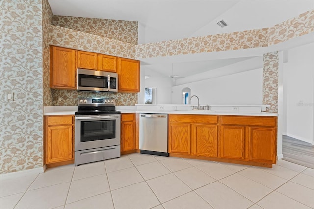 kitchen featuring sink, stainless steel appliances, high vaulted ceiling, and light tile patterned flooring