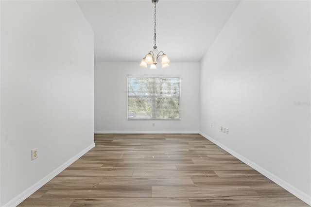 unfurnished dining area featuring a chandelier and light wood-type flooring