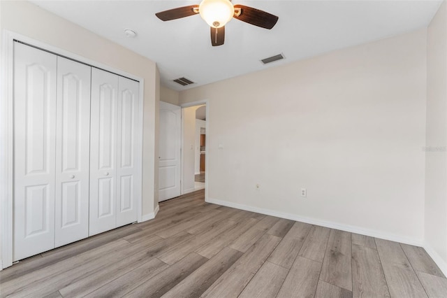 unfurnished bedroom with ceiling fan, a closet, and light wood-type flooring