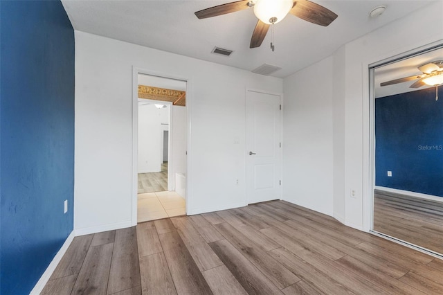 unfurnished bedroom featuring light hardwood / wood-style flooring, a closet, and ceiling fan