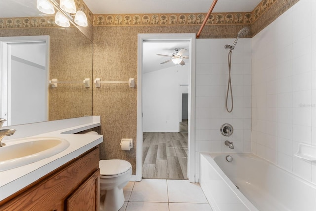 full bathroom featuring ceiling fan, vanity, tiled shower / bath, tile patterned floors, and toilet