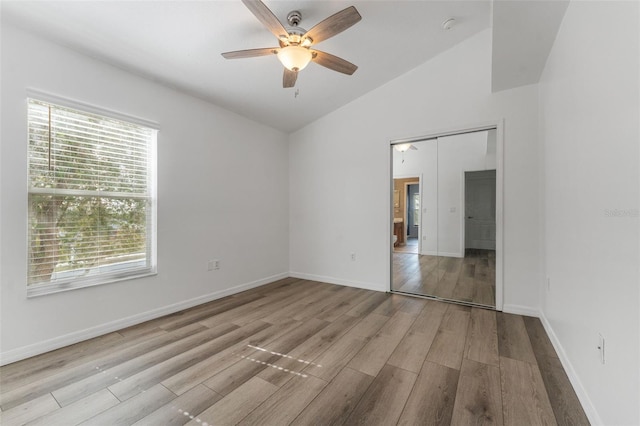 unfurnished room with lofted ceiling, ceiling fan, and light wood-type flooring