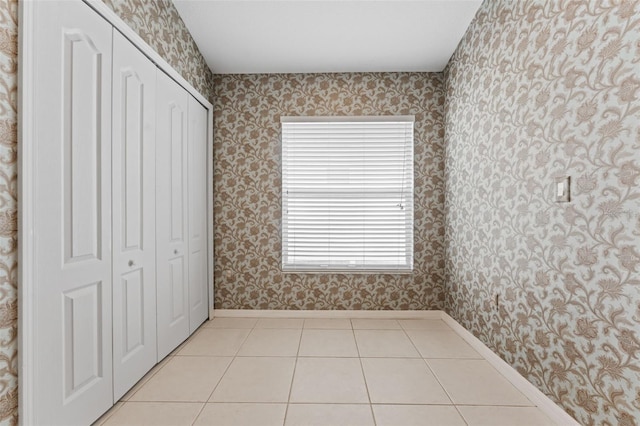 unfurnished bedroom featuring light tile patterned floors and a closet