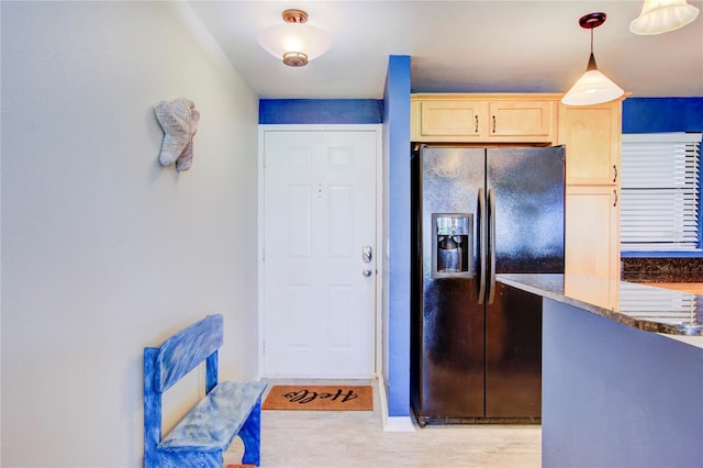 kitchen featuring black fridge, stone countertops, pendant lighting, and light brown cabinets