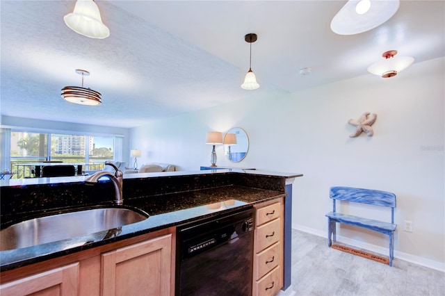 kitchen featuring pendant lighting, sink, dark stone countertops, black dishwasher, and light brown cabinets