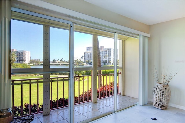 doorway to outside featuring a water view and light tile patterned flooring