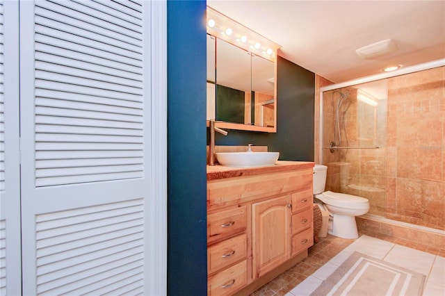 bathroom featuring vanity, an enclosed shower, tile patterned floors, and toilet