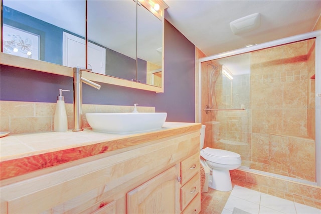 bathroom featuring a shower with door, vanity, tile patterned floors, and toilet