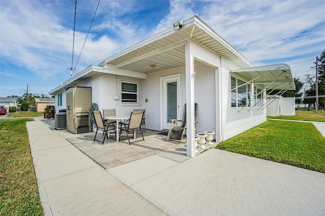 back of property featuring a lawn and a patio