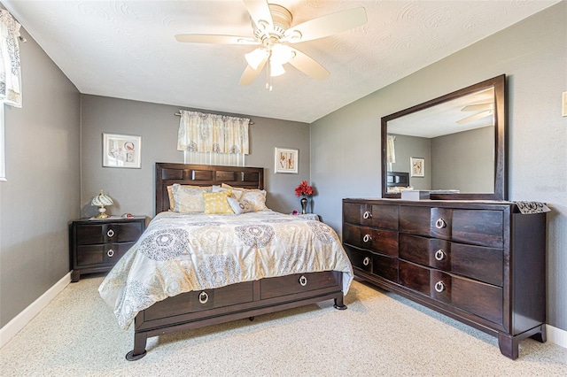 bedroom with ceiling fan and a textured ceiling