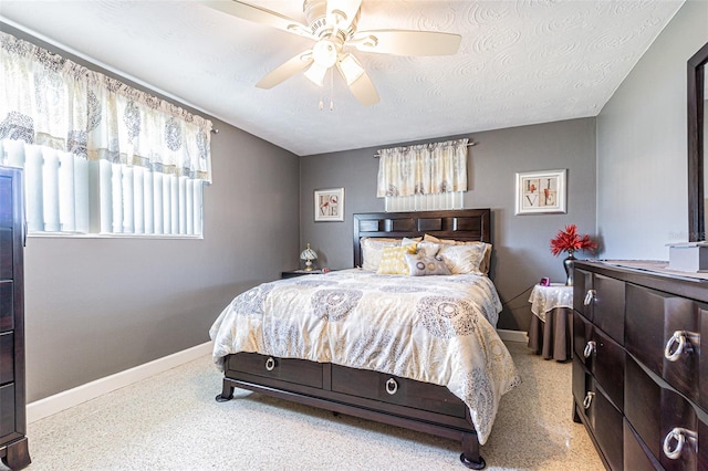 bedroom with ceiling fan and a textured ceiling