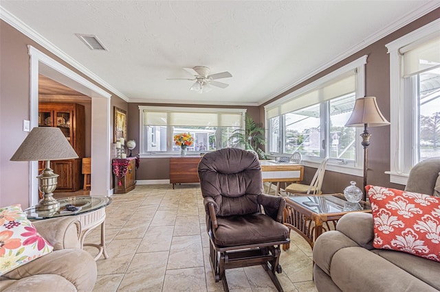 living room featuring crown molding, ceiling fan, and a textured ceiling