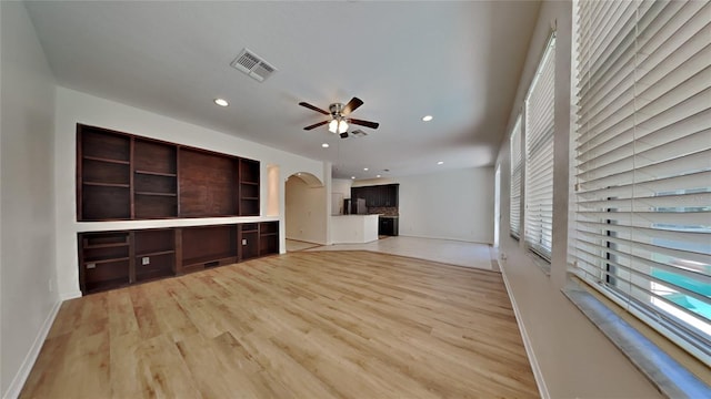 unfurnished living room with ceiling fan and light wood-type flooring