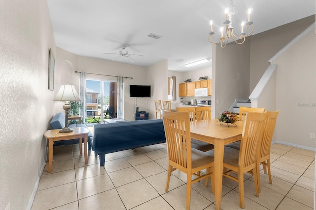 tiled dining area featuring ceiling fan with notable chandelier