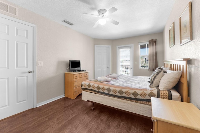 bedroom with dark hardwood / wood-style flooring, a textured ceiling, and ceiling fan