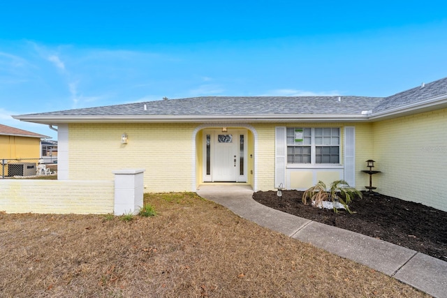 doorway to property with a lawn