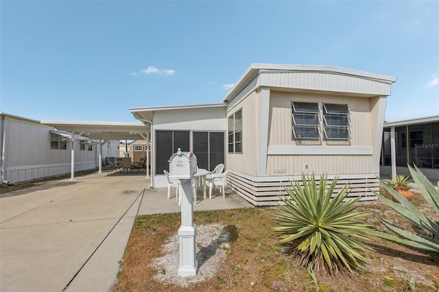 manufactured / mobile home with a carport and a sunroom