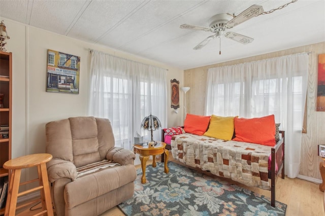 living room featuring ceiling fan, a healthy amount of sunlight, and light hardwood / wood-style flooring