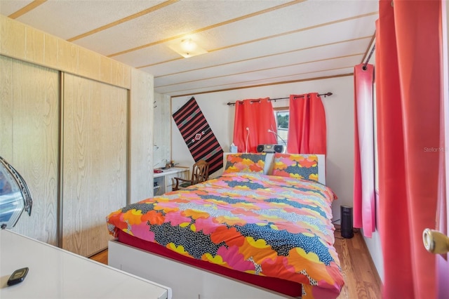 bedroom with hardwood / wood-style flooring, a closet, and a textured ceiling