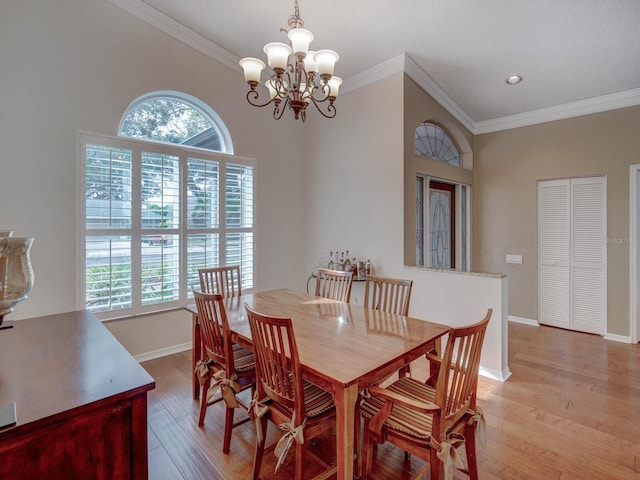 dining room with ornamental molding, a notable chandelier, and light hardwood / wood-style flooring