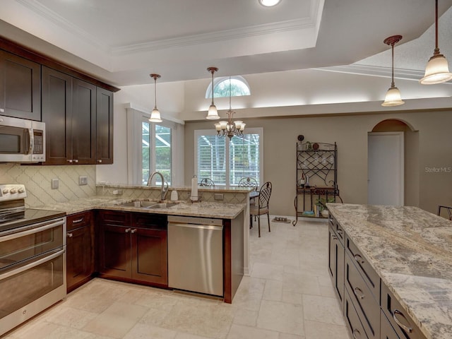 kitchen featuring sink, decorative light fixtures, a raised ceiling, and appliances with stainless steel finishes