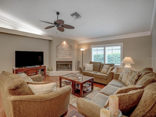 living room featuring lofted ceiling, crown molding, a textured ceiling, light wood-type flooring, and ceiling fan