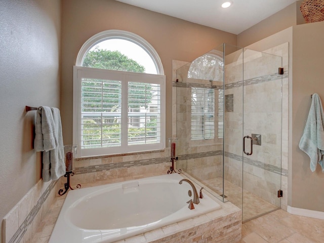 bathroom featuring independent shower and bath and a healthy amount of sunlight