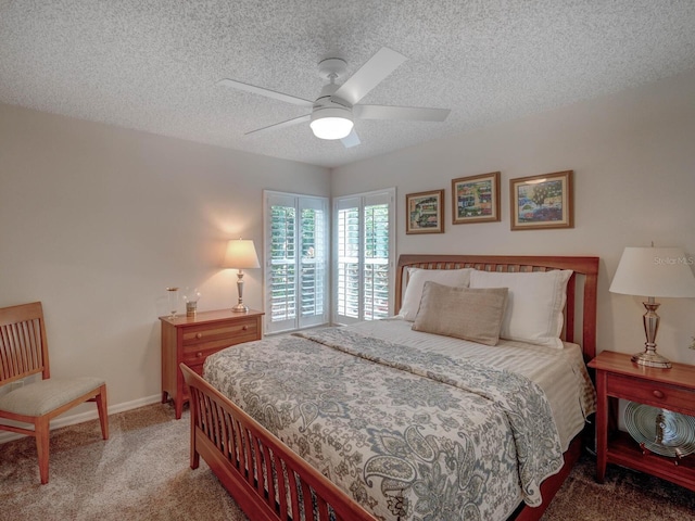 bedroom with ceiling fan, carpet floors, and a textured ceiling