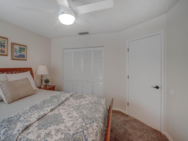 bedroom with ceiling fan, carpet floors, a closet, and a textured ceiling