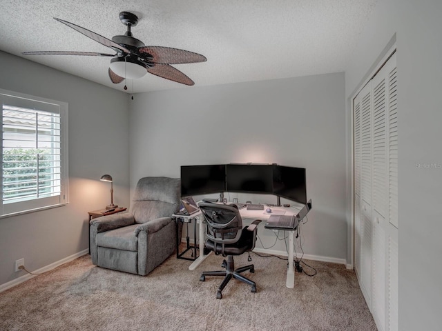 carpeted home office featuring ceiling fan and a textured ceiling