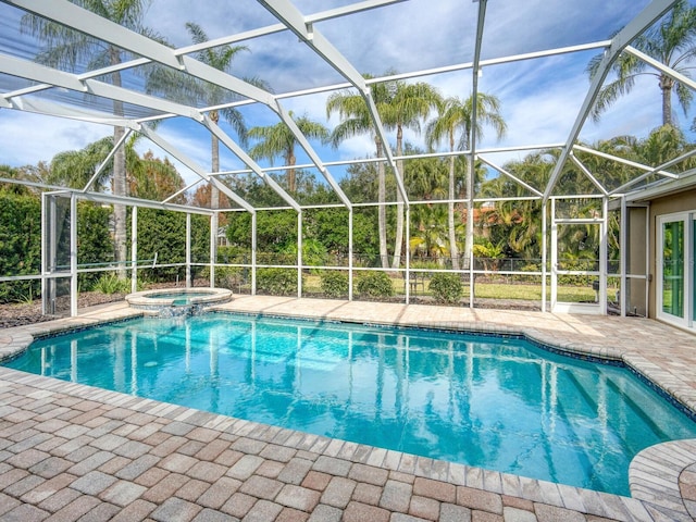 view of pool with an in ground hot tub, a patio, and glass enclosure