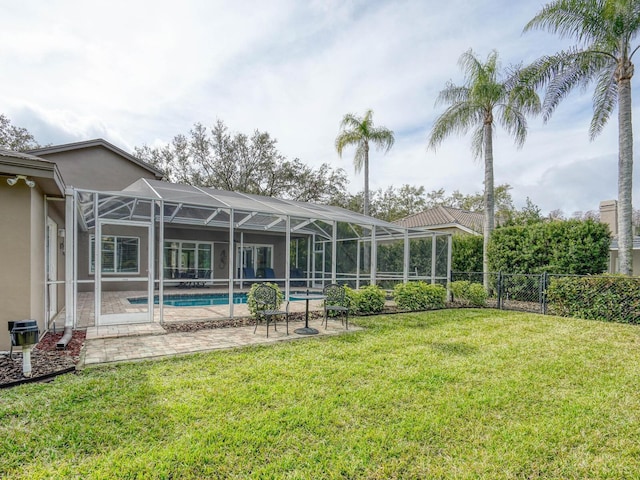 back of house with a fenced in pool, a yard, a patio area, and glass enclosure