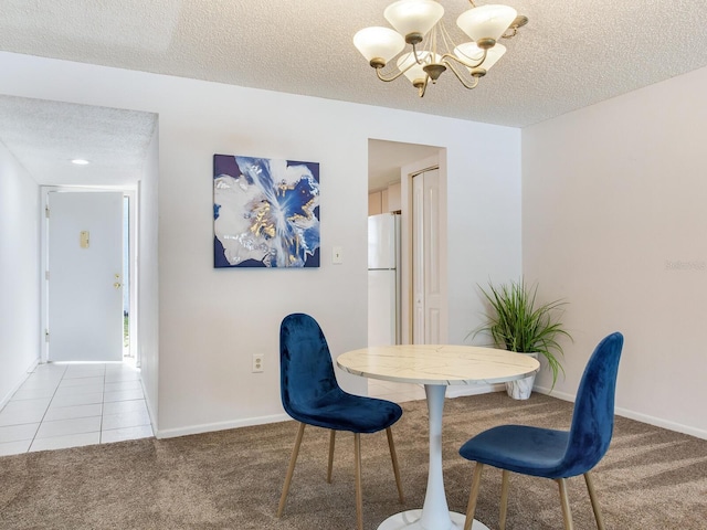 dining room with carpet, an inviting chandelier, and a textured ceiling