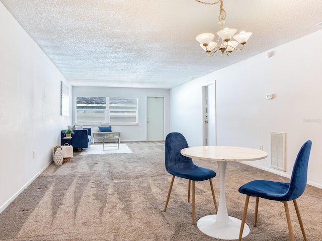 carpeted dining area with a textured ceiling and a notable chandelier