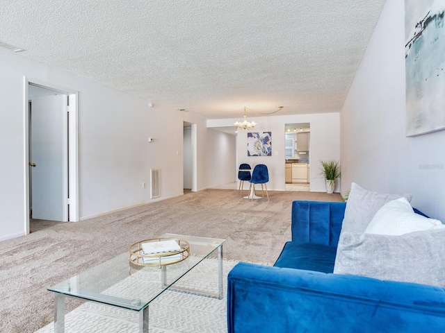 carpeted living room featuring a chandelier and a textured ceiling