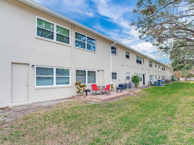 back of property featuring central AC, a patio, and a lawn