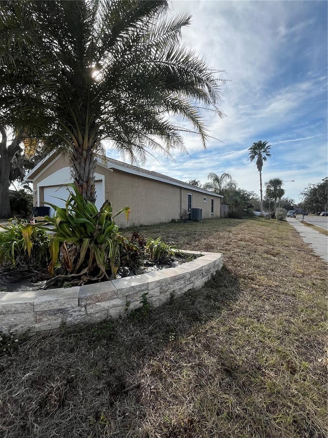 view of side of property with a garage and central air condition unit